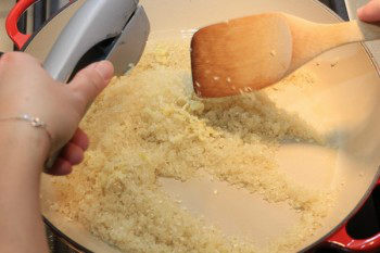 garlic added to rice in a cast iron pan