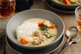 A gray bowl containing Japanese Cream Stew (White Stew) with chicken and vegetables in a savory thick white sauce.