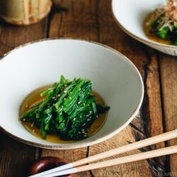 Spinach ohitashi in white ceramic plates.