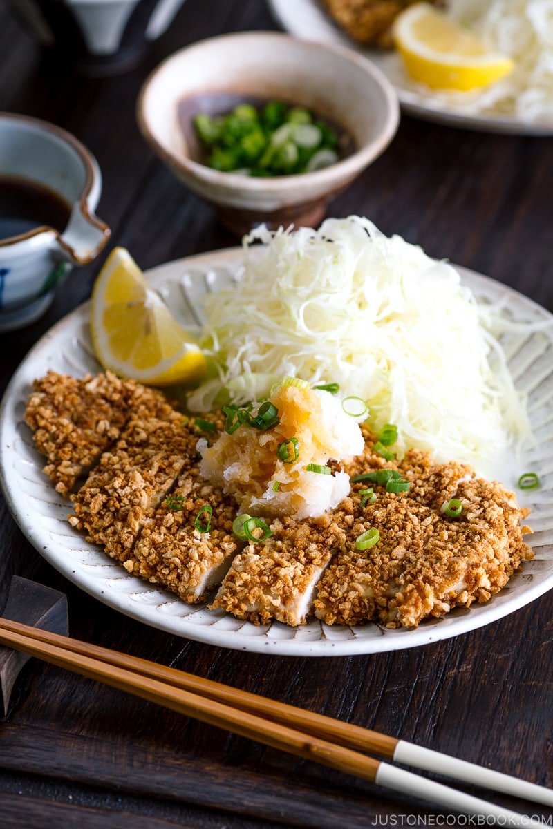 GlutGluten Free Baked Chicken Katsu with cabbage salad and sliced lemon on the plate.