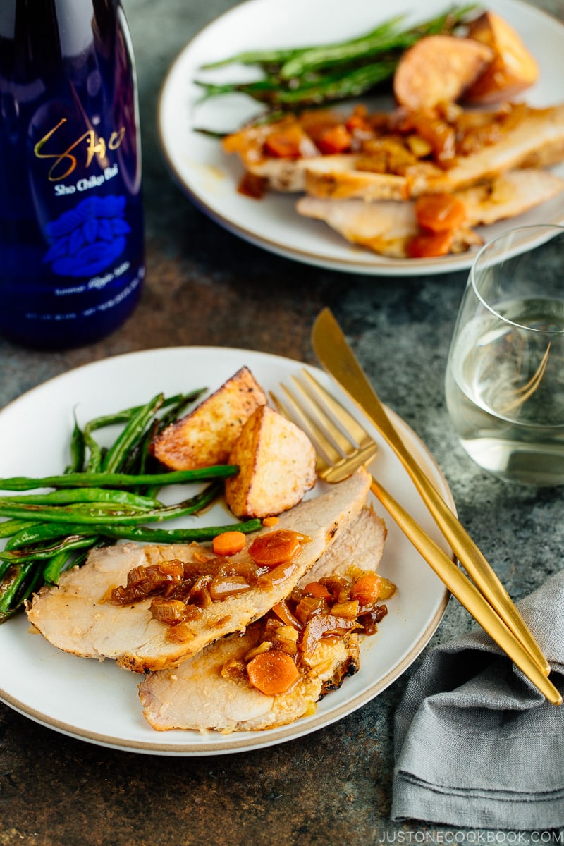 Plates containing sliced Japanese Pork Roast, green beans, and roasted potatoes.
