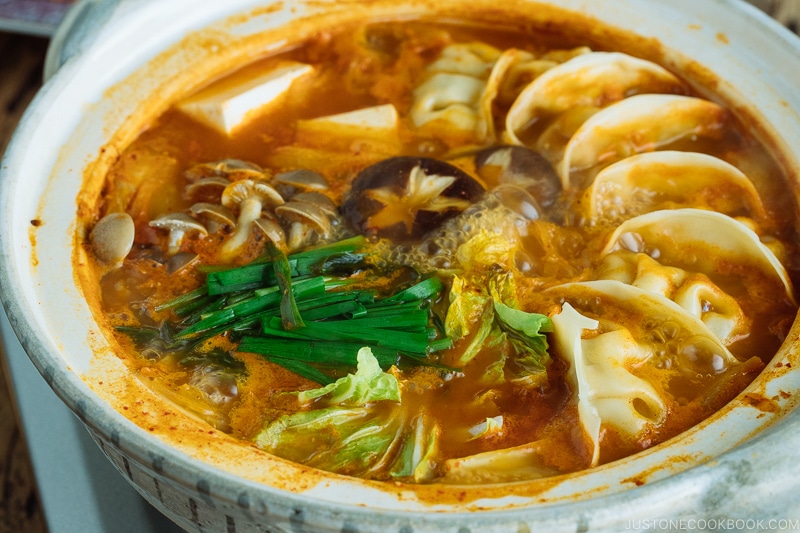A donabe hot pot containing kimchi gyoza hot pot stew.
