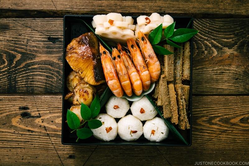 Shirmp, scallop, fish, pickles, lotus root, and gobo in the osechi box.