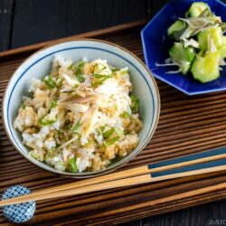 A Japanese rice bowl containing Myoga Shiso Rice (Mazegohan) served with pickled cucumber.