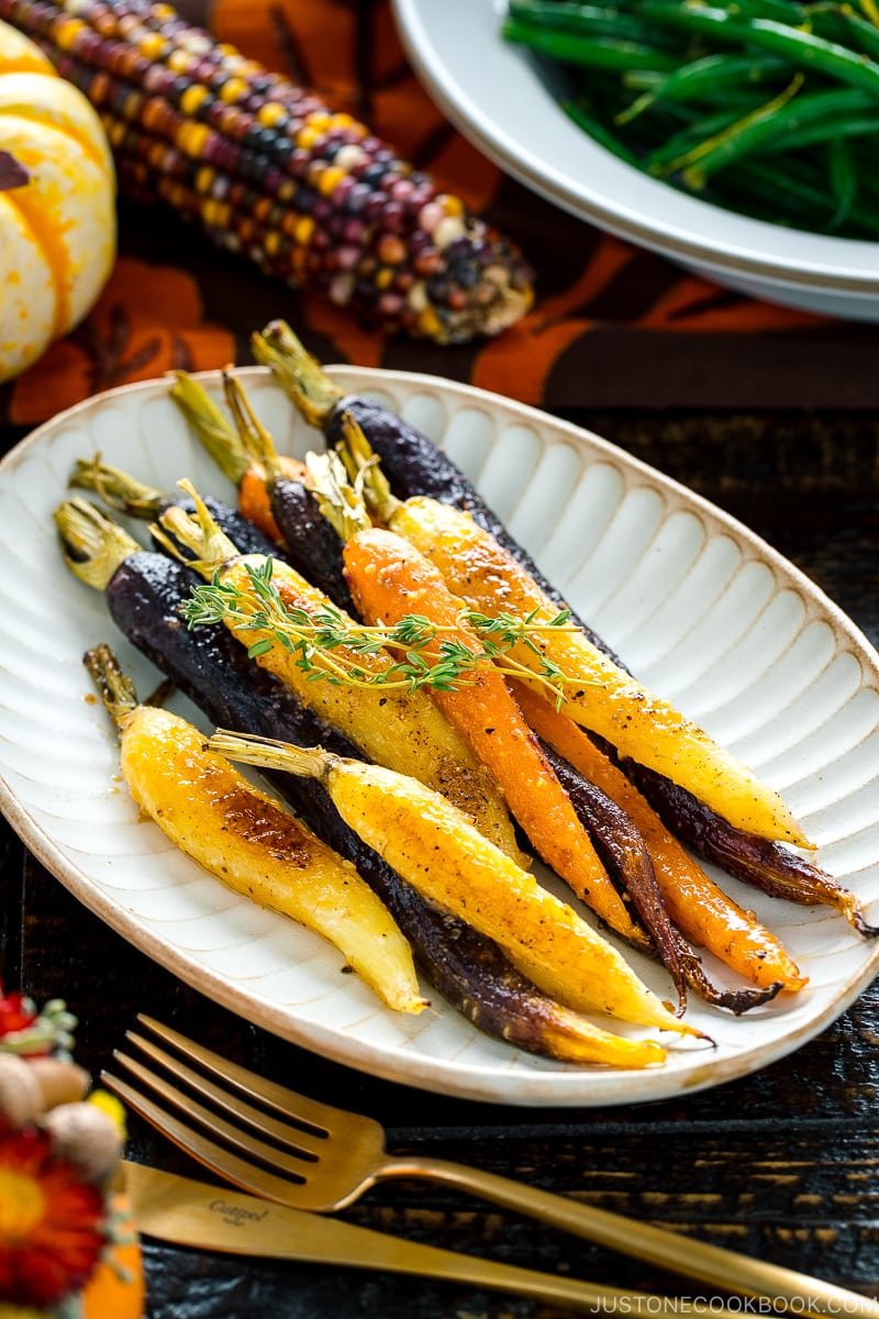 A white ceramic plate containing Maple and Miso Glazed Roasted Carrots.