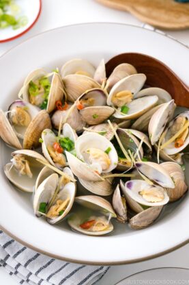 A ceramic bowl containing Japanese Sake-Steamed Clams.
