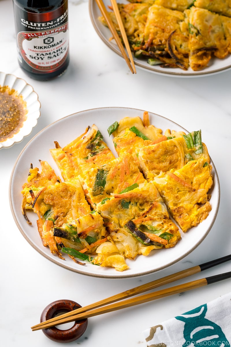 A white plate containing gluten free Korean veggie pancake.
