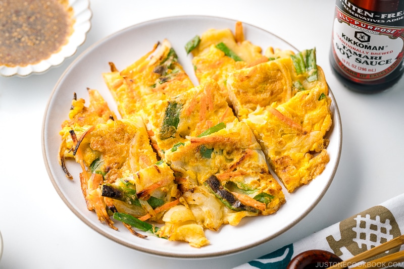 A white plate containing gluten free Korean veggie pancake.