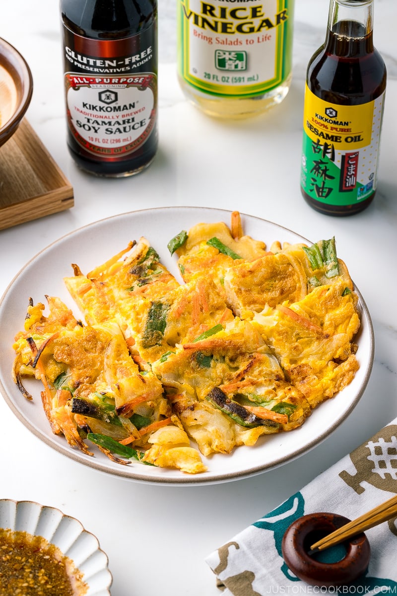 A white plate containing gluten free Korean veggie pancake.