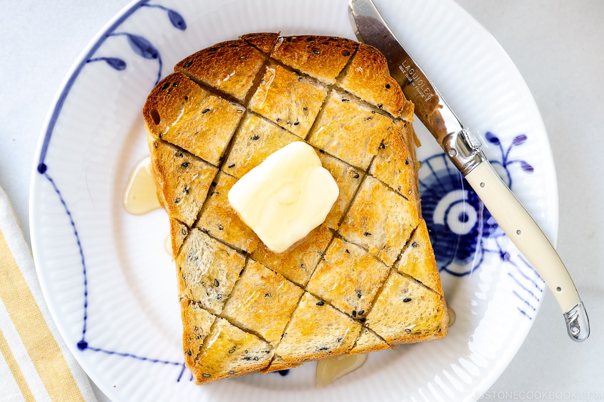 A toasted Black Sesame Shokupan with butter and honey on top.