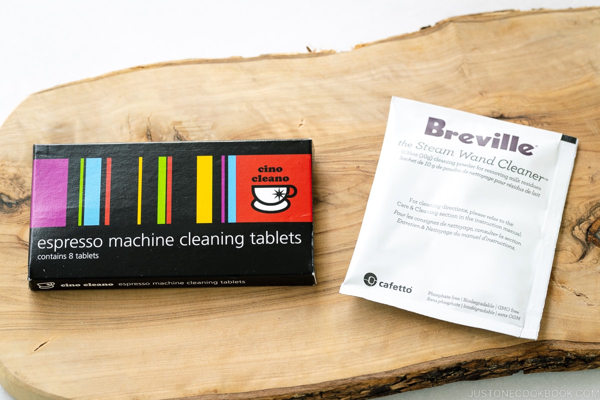 2 espresso machine cleaning packages on a wooden board