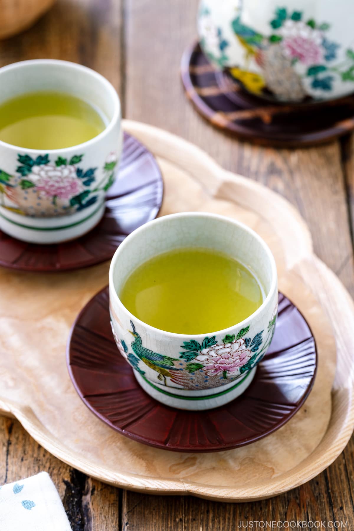 green tea in 2 ceramic teacups on a wooden table