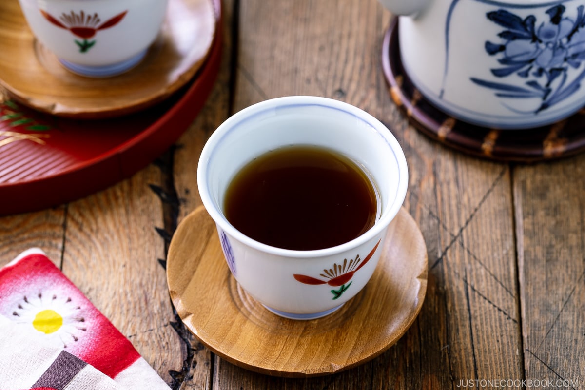 2 teacups with hojicha on a wooden table