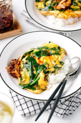A white plate containing Stir-Fried Garlic Chives and Egg Over Rice.