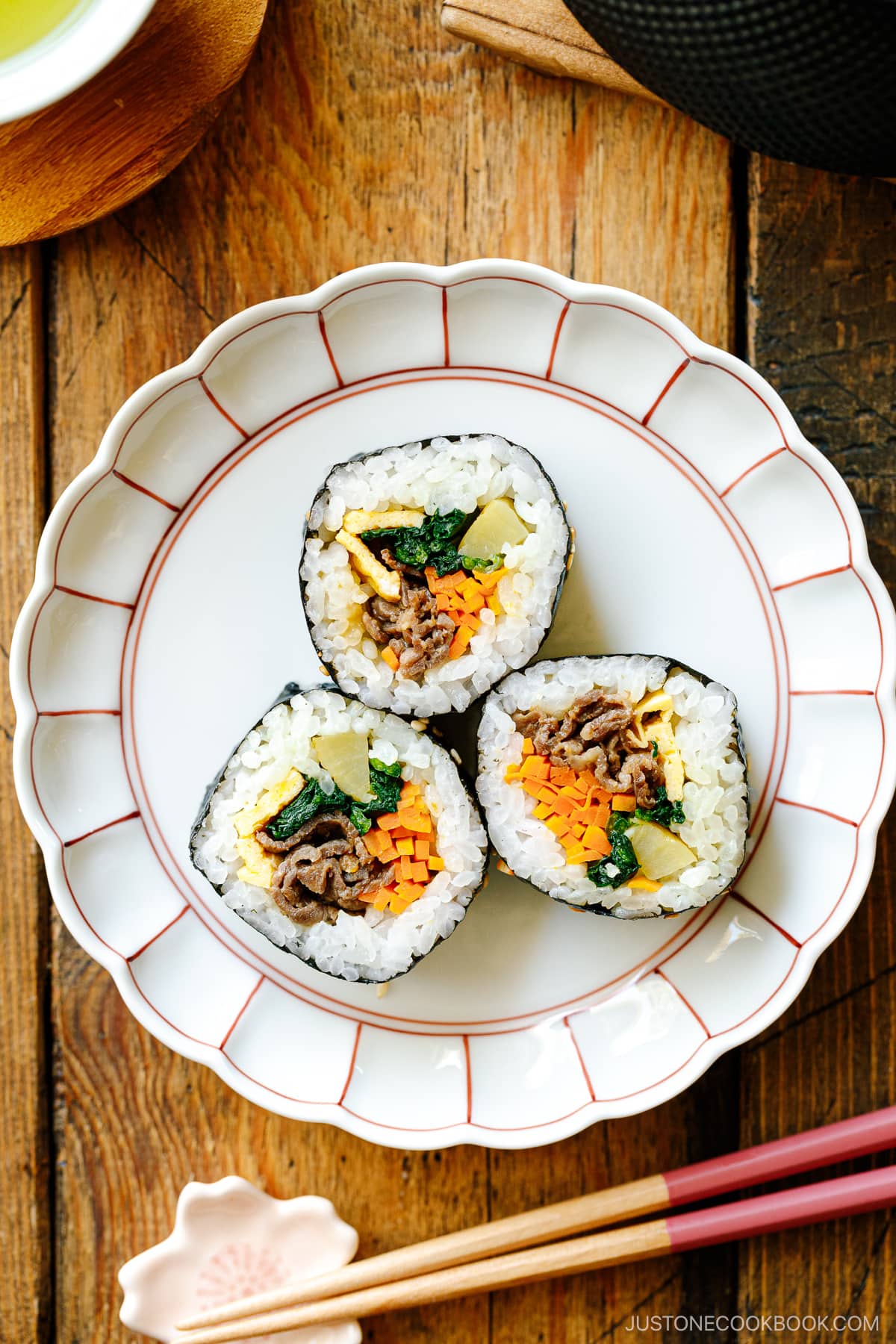A round plate containing three sliced Kimbap (Korean Seaweed Roll).