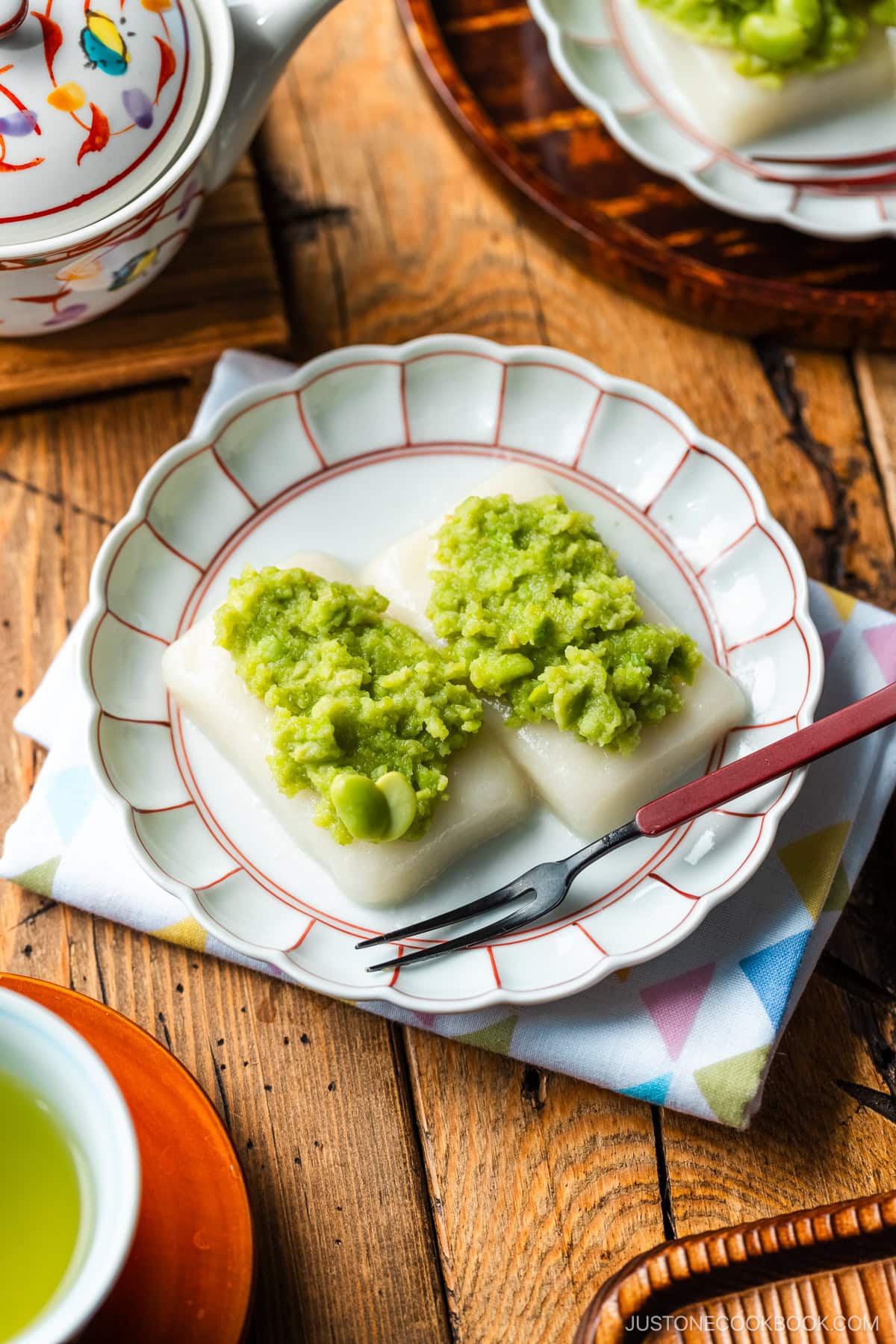 A fluted plate containing Zunda Mochi, topped with sweet edamame paste.