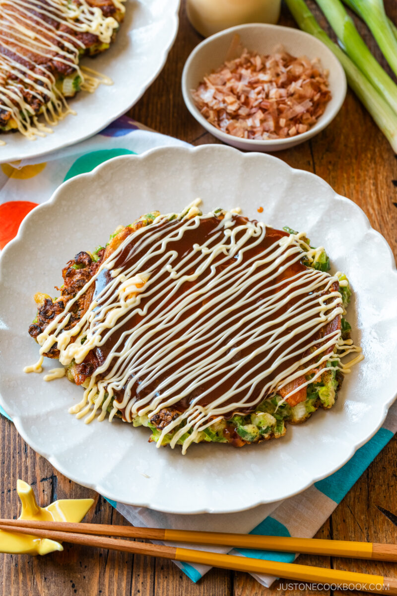 White scalloped plates containing negiyaki, a savory Japanese scallion pancake.