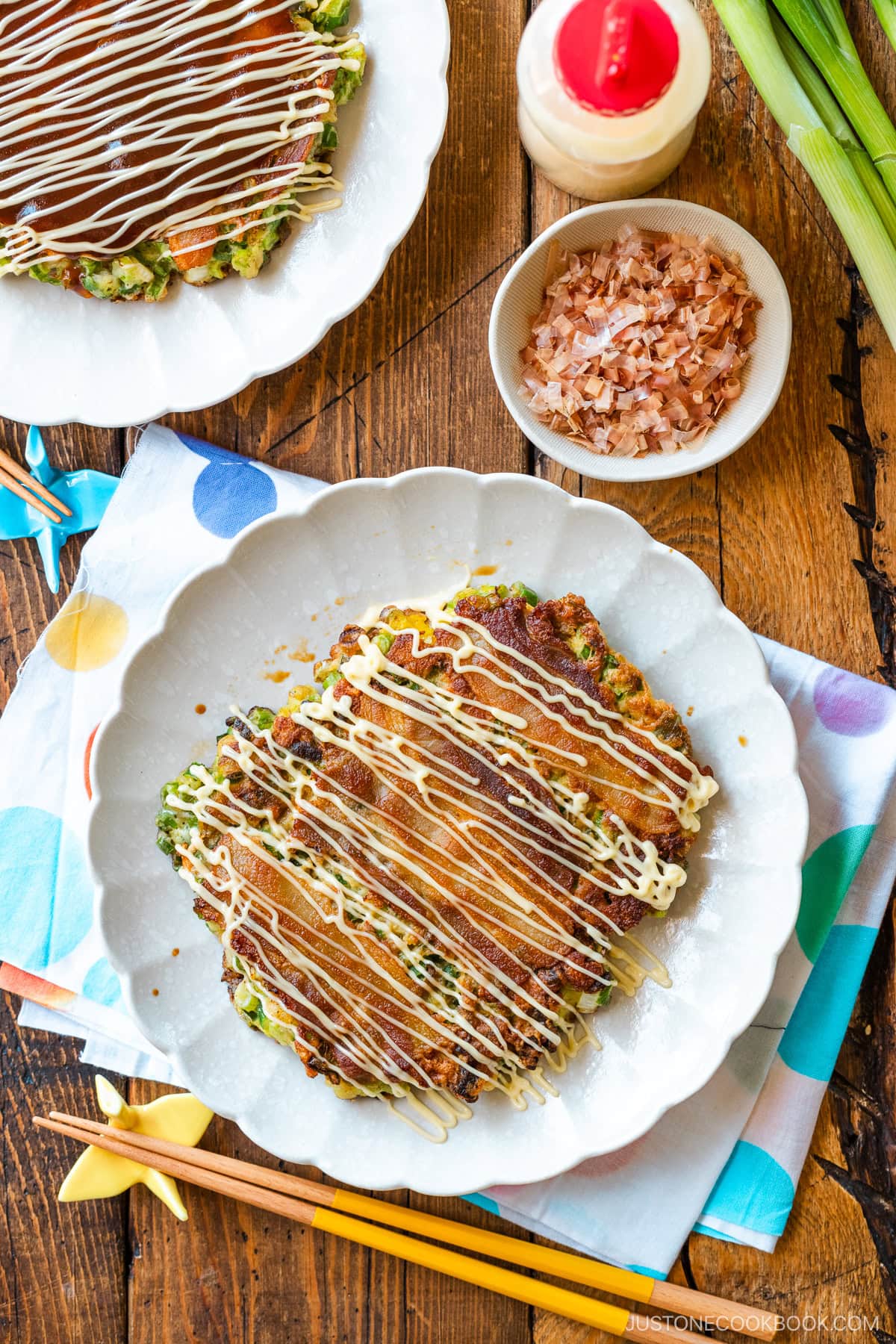 White scalloped plates containing negiyaki, a savory Japanese scallion pancake.