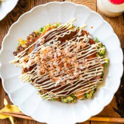 White scalloped plates containing negiyaki, a savory Japanese scallion pancake.