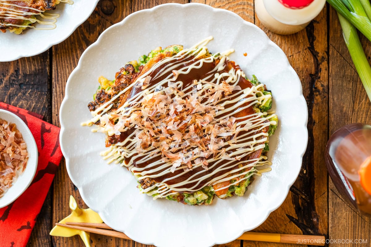 White scalloped plates containing negiyaki, a savory Japanese scallion pancake.