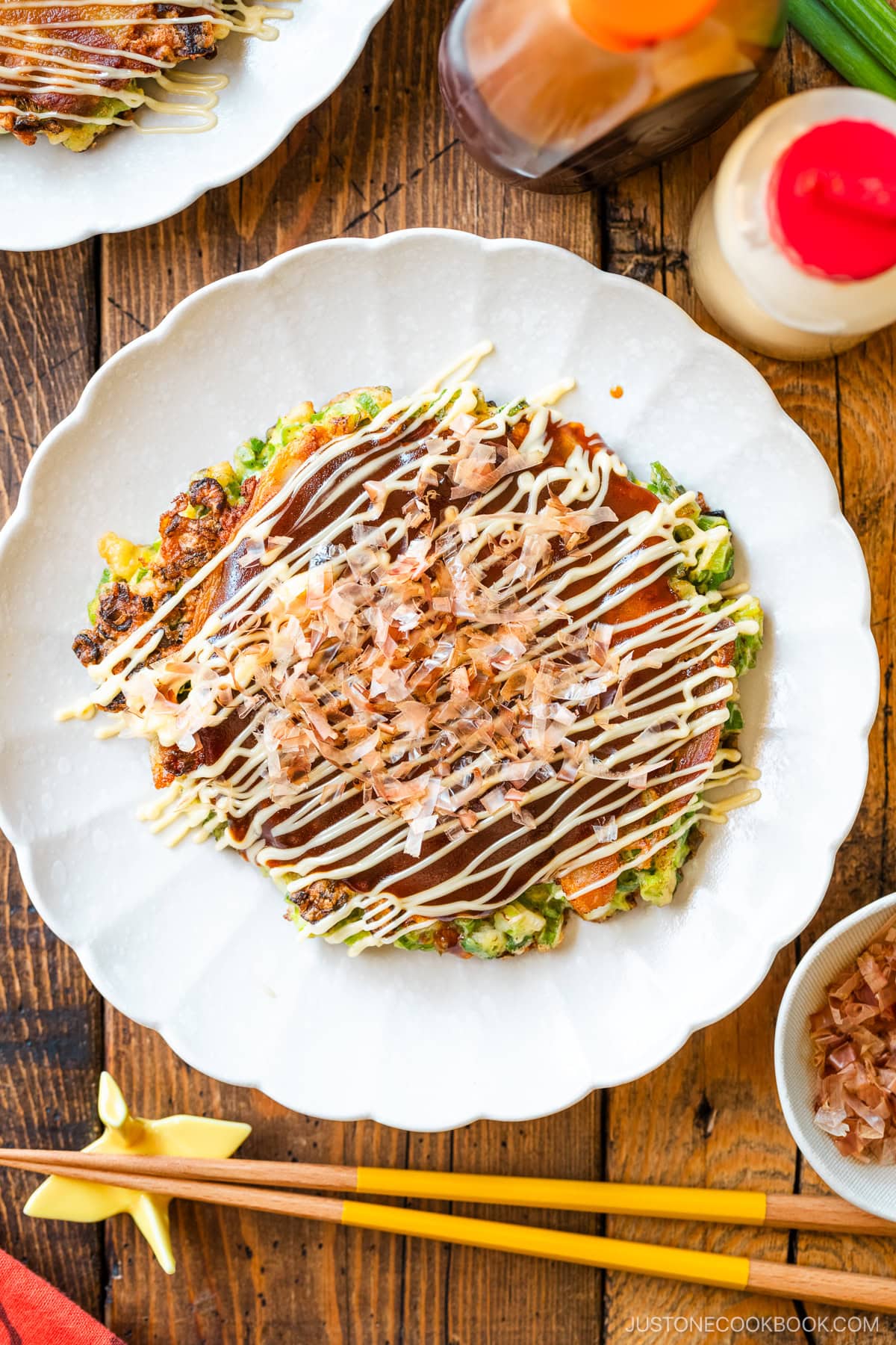 White scalloped plates containing negiyaki, a savory Japanese scallion pancake.