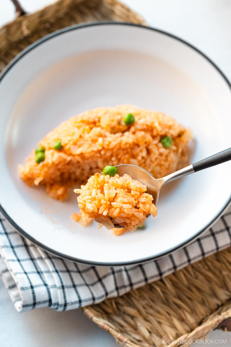 A white plate containing Rice Cooker Chicken Rice, seasoned with Japanese ketchup and Worcestershire sauce.