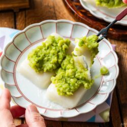 A fluted plate containing Zunda Mochi, topped with sweet edamame paste.