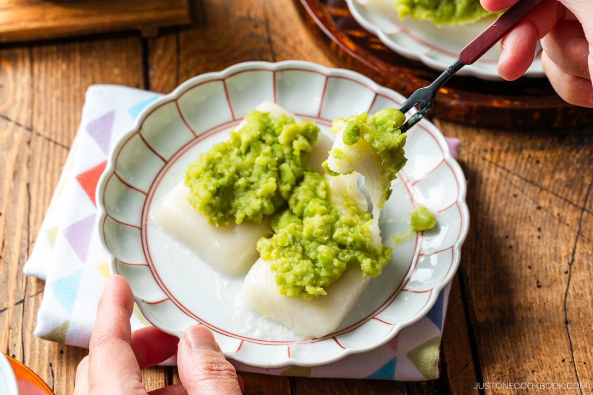 A fluted plate containing Zunda Mochi, topped with sweet edamame paste.