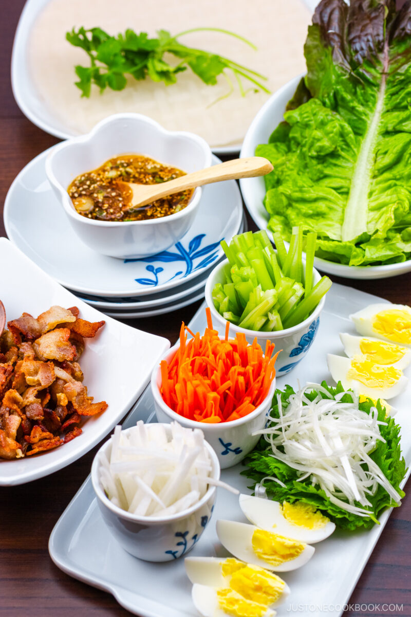 A white plate containing Pork Spring Rolls with Ponzu.