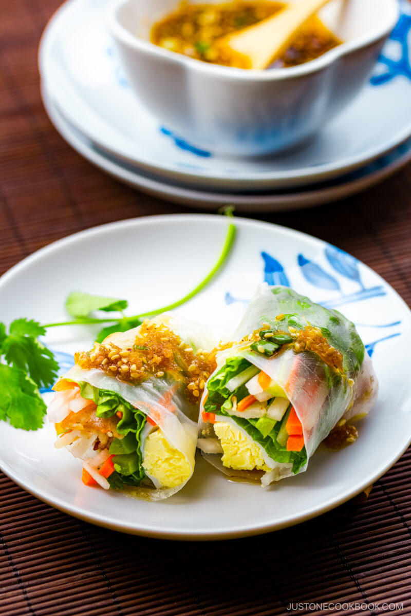 A white plate containing Pork Spring Rolls with Ponzu.