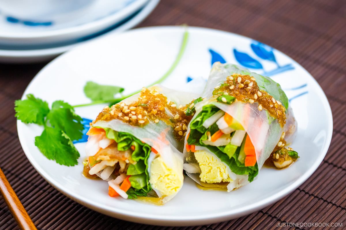 A white plate containing Pork Spring Rolls with Ponzu.