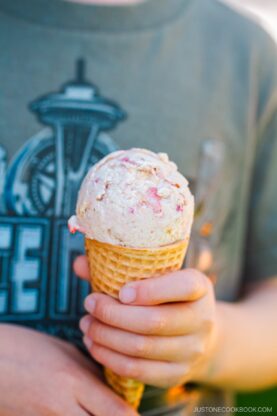 A waffle cone containing strawberry ice cream.