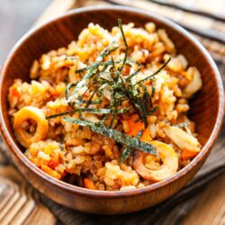 Wooden rice bowls containing gobo and miso takikomi gohan or Japanese mixed rice dish withburdock root and carrots seasoned with miso.