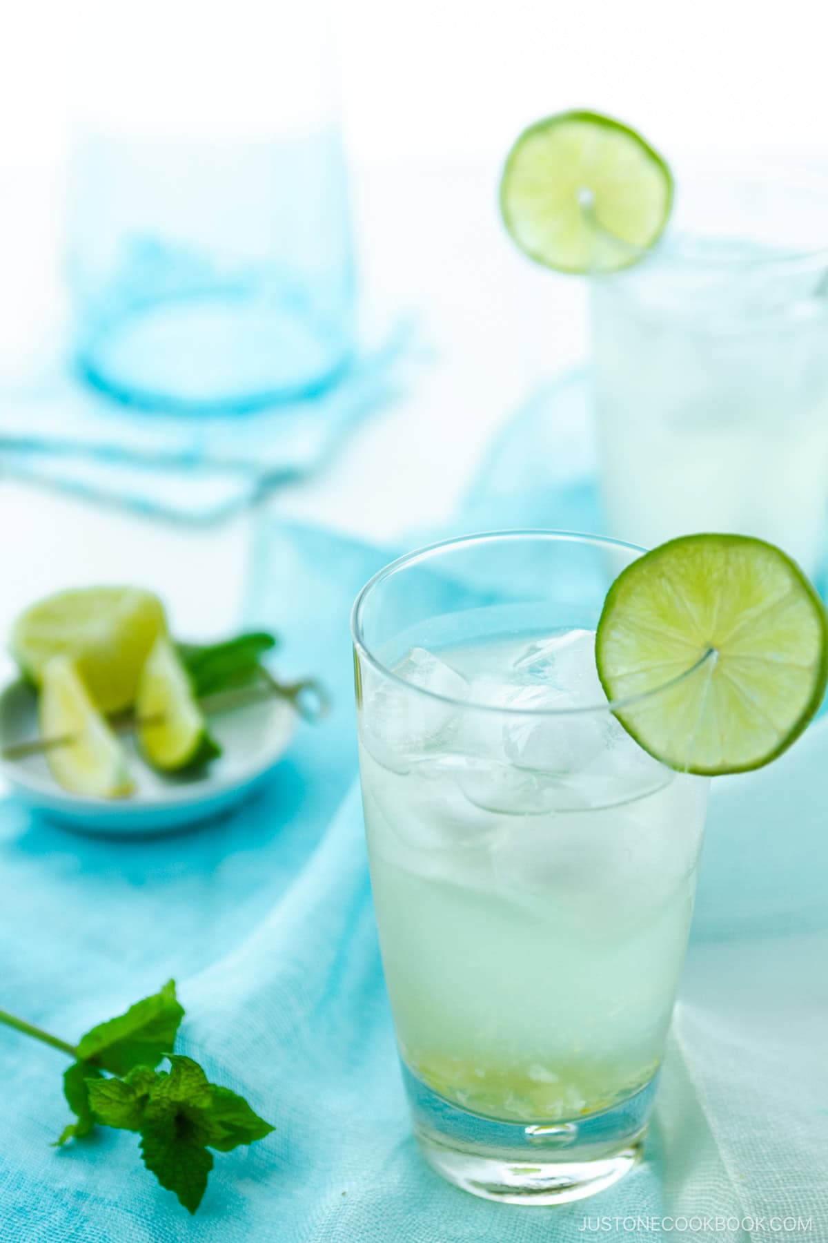 A glass filled with Japanese Yuzu Cocktail (Yuzu Chuhai) garnished with a slice of lime.
