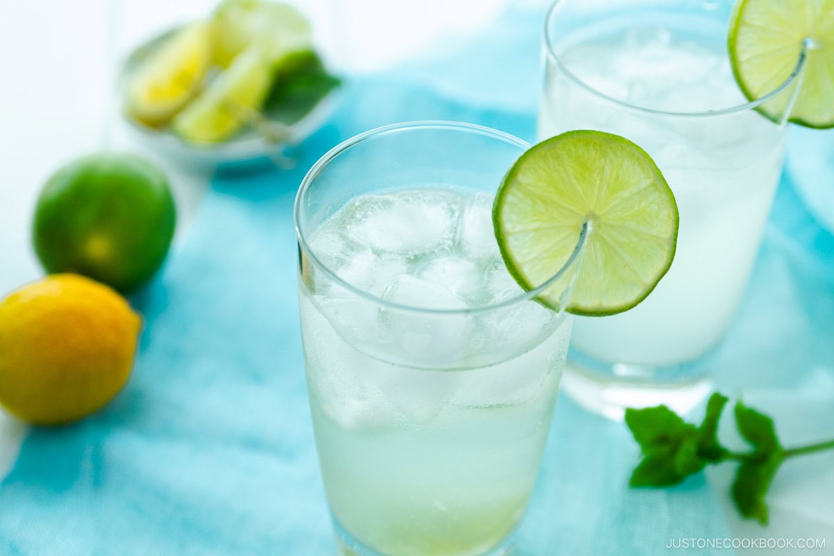 A glass filled with Japanese Yuzu Cocktail (Yuzu Chuhai) garnished with a slice of lime.