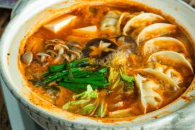 Kimchi Gyoza Nabe served in donabe (Japanese earthenware pot).