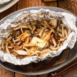 Assortment of mushrooms are wrapped and cooked in foil with miso and butter.