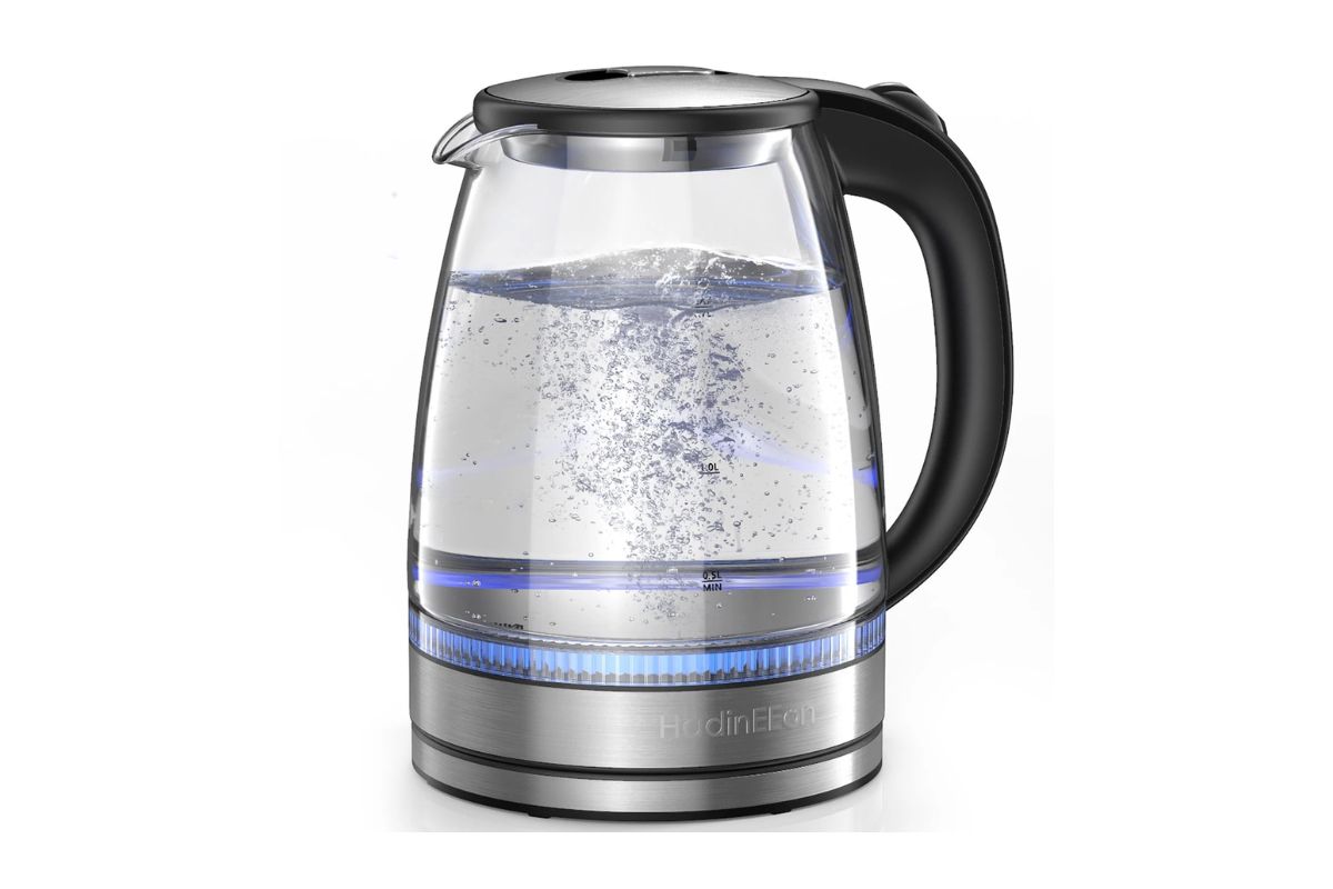 Clear glass electric kettle boiling water with visible steam, stainless steel base, black handle, and modern design. Perfect for tea, coffee, or everyday hot water needs in a contemporary kitchen.