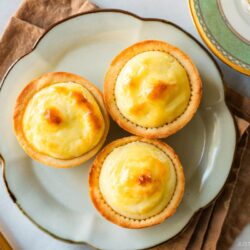 A flower shaped-plate containing baked cheese tarts.