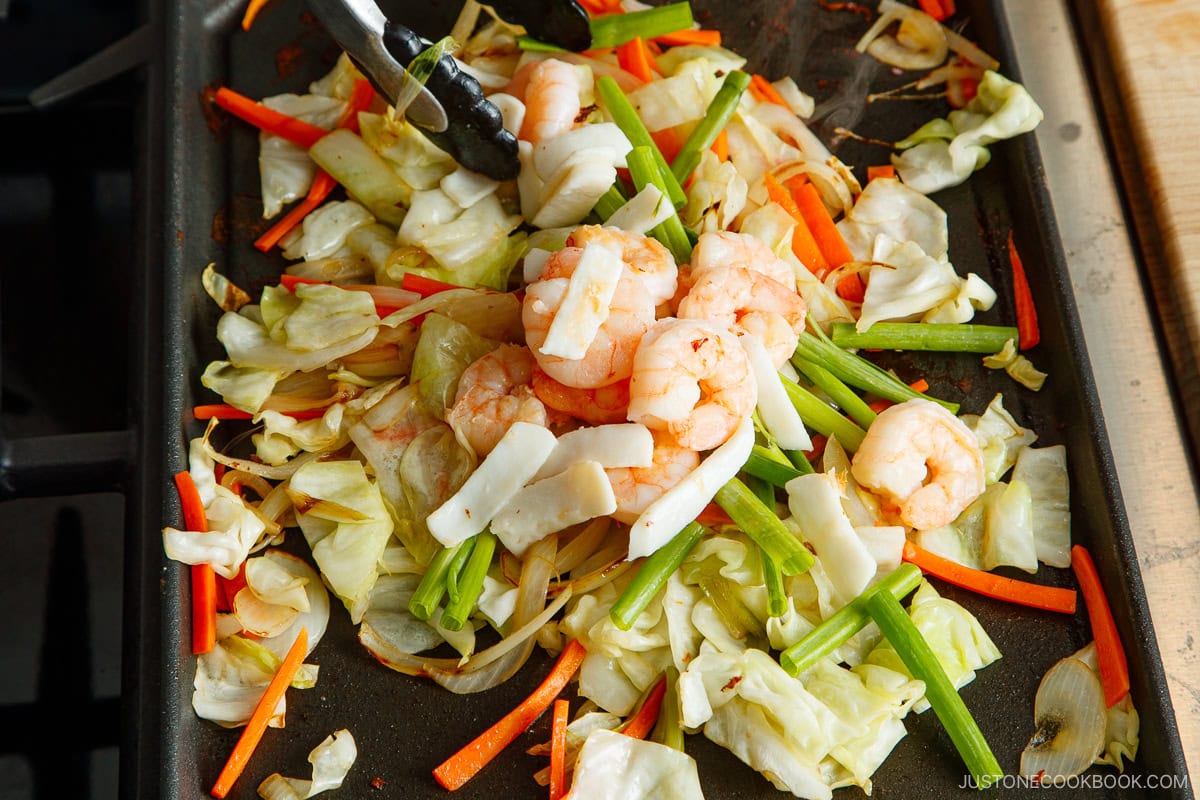 Stir fry the vegetables and seafood on the griddle.