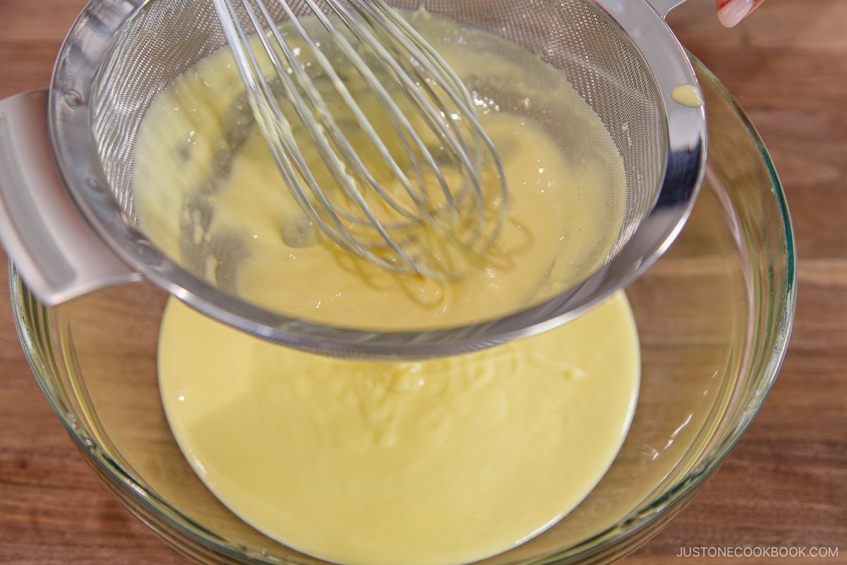 Passing the batter through a fine mesh sieve.
