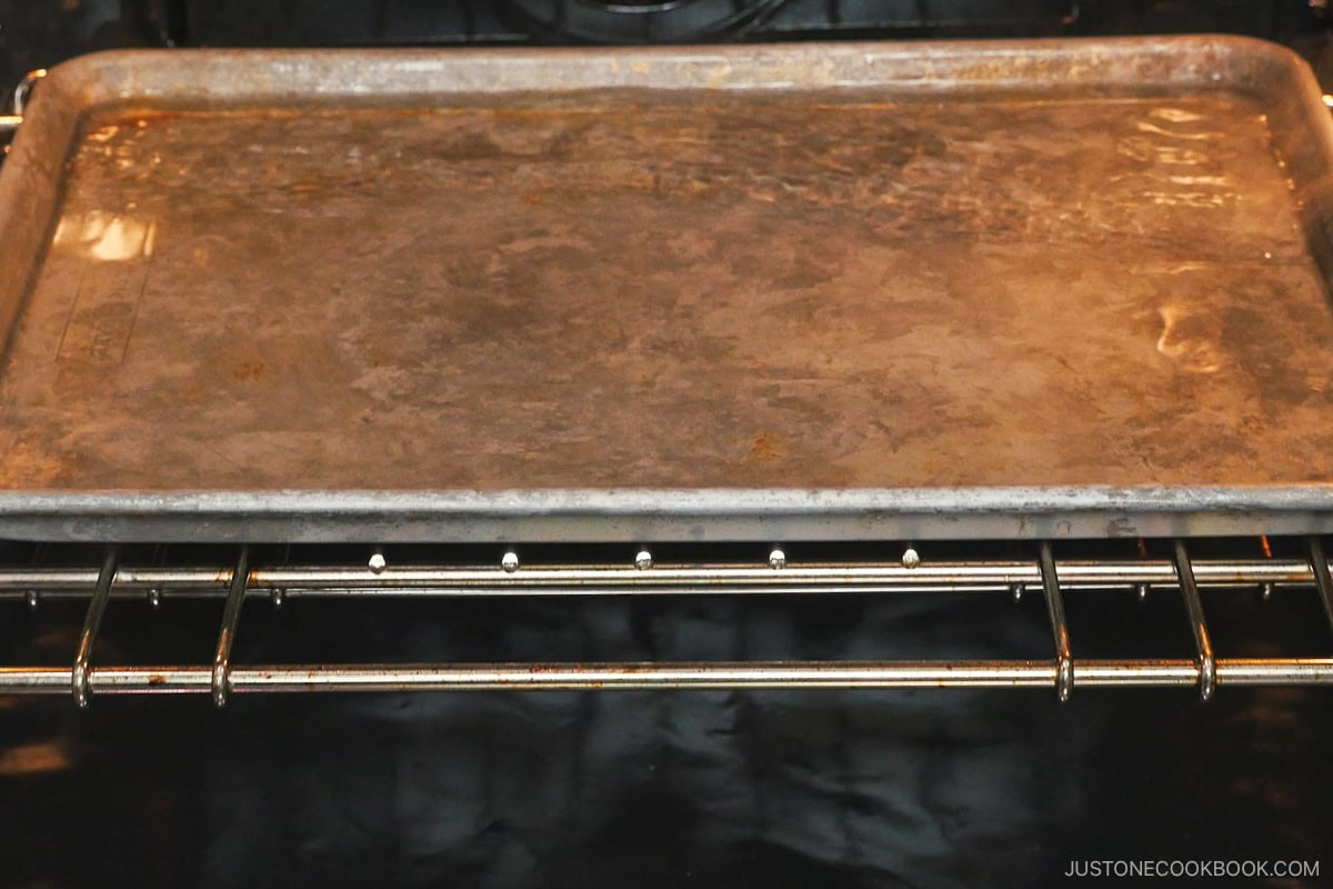 Adding hot water in the baking sheet.