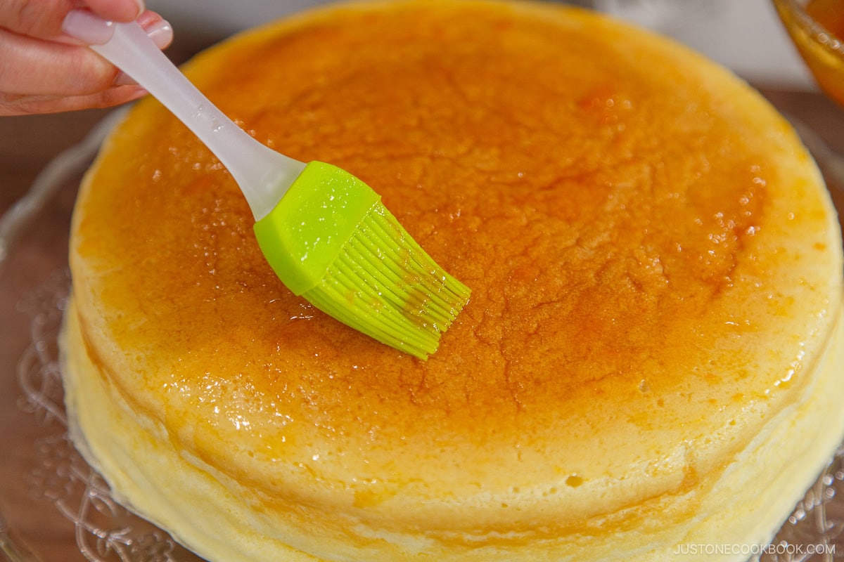 Applying the apricot jam over the cake.