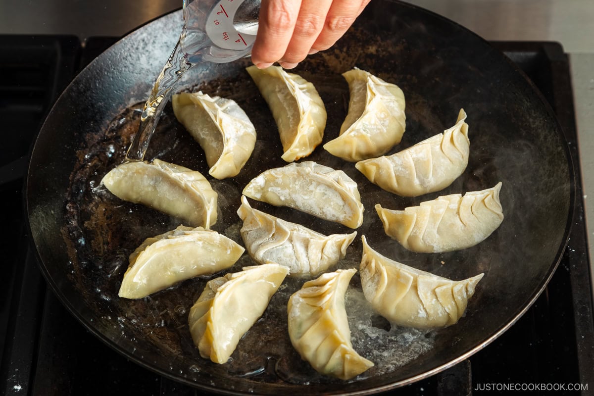 Adding water to the frying pan.