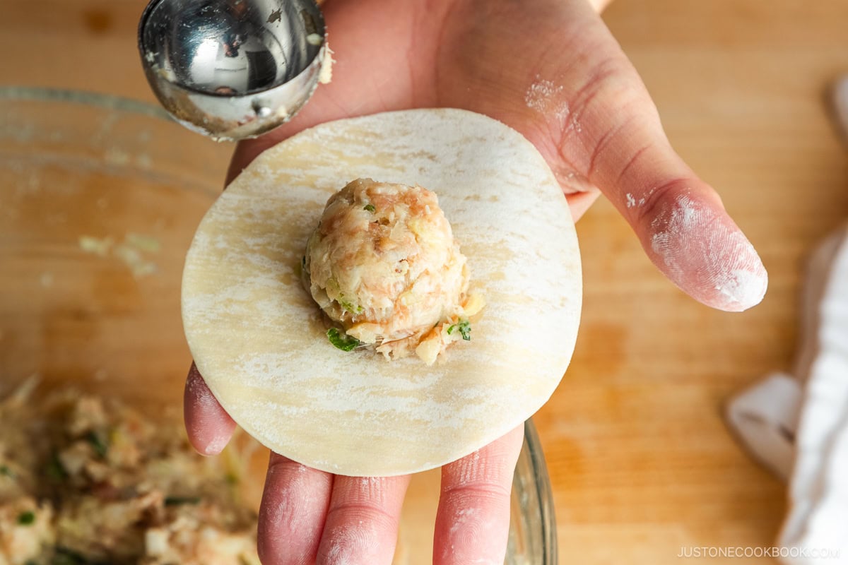 Adding the filling to the gyoza wrapper.