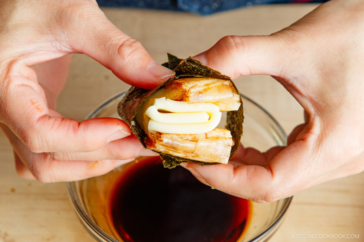 Stuffing cheese and wrapping nori around mochi.