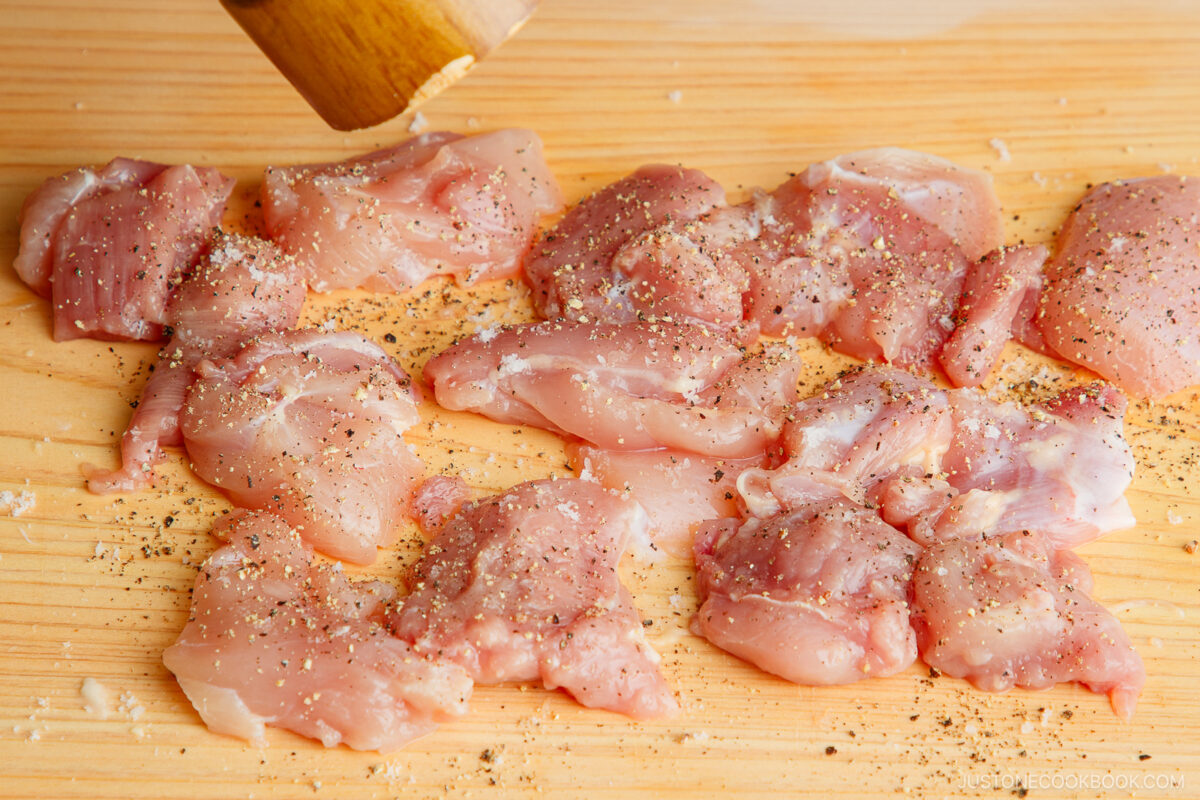 Seasoning salt and pepper on the chicken pieces.