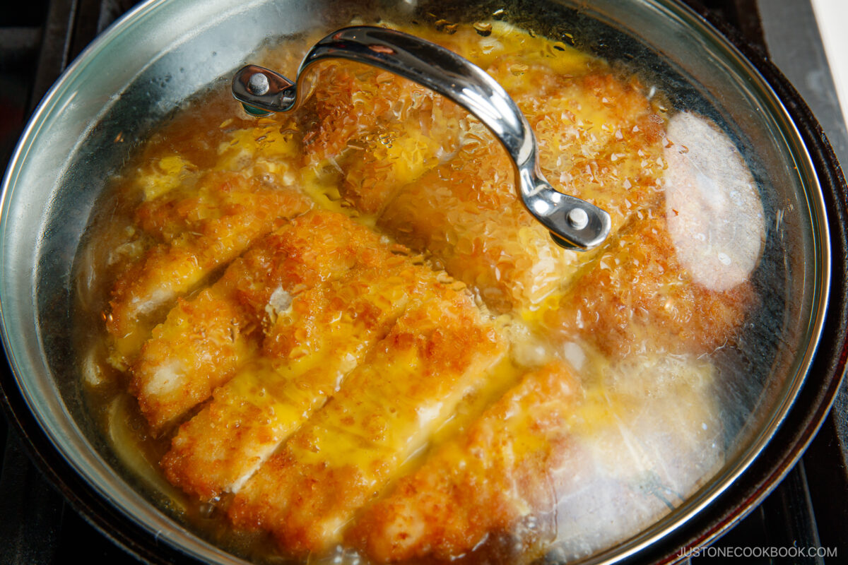 Simmering tonkatsu with eggs in the dashi broth.