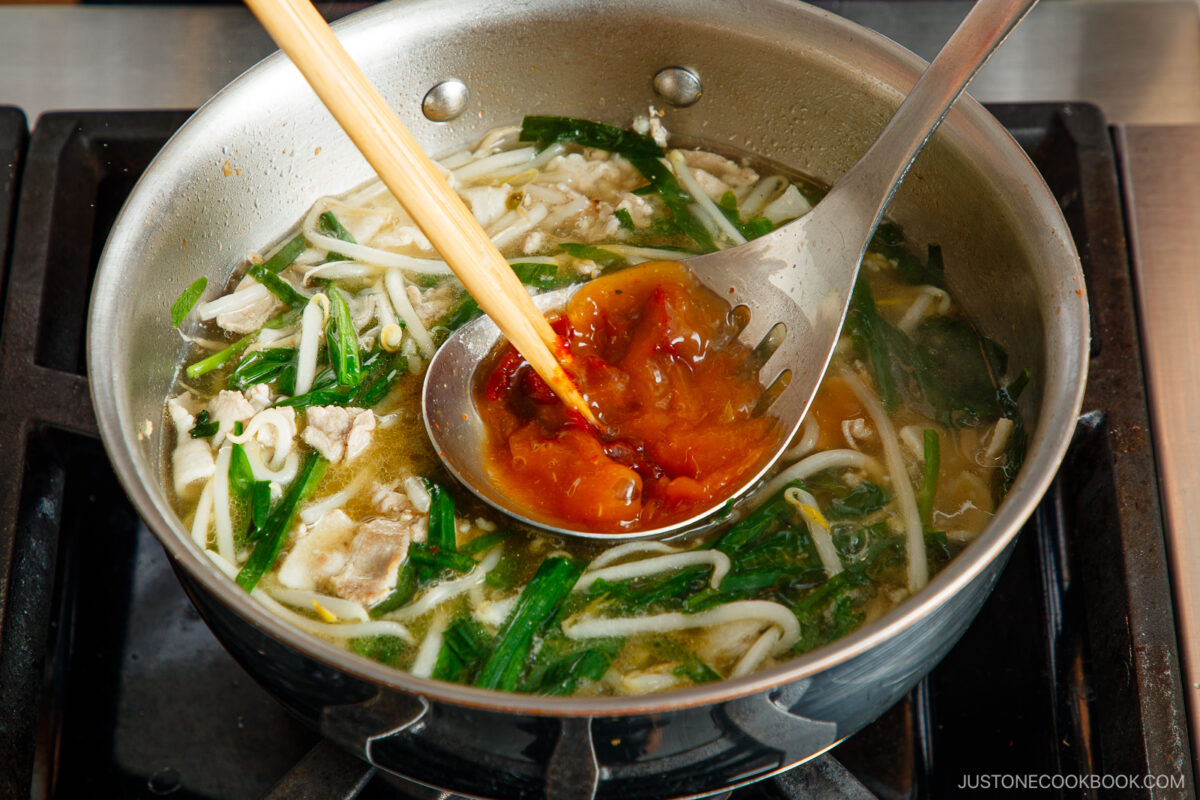 Dissoloving the gochujang in the ladle.