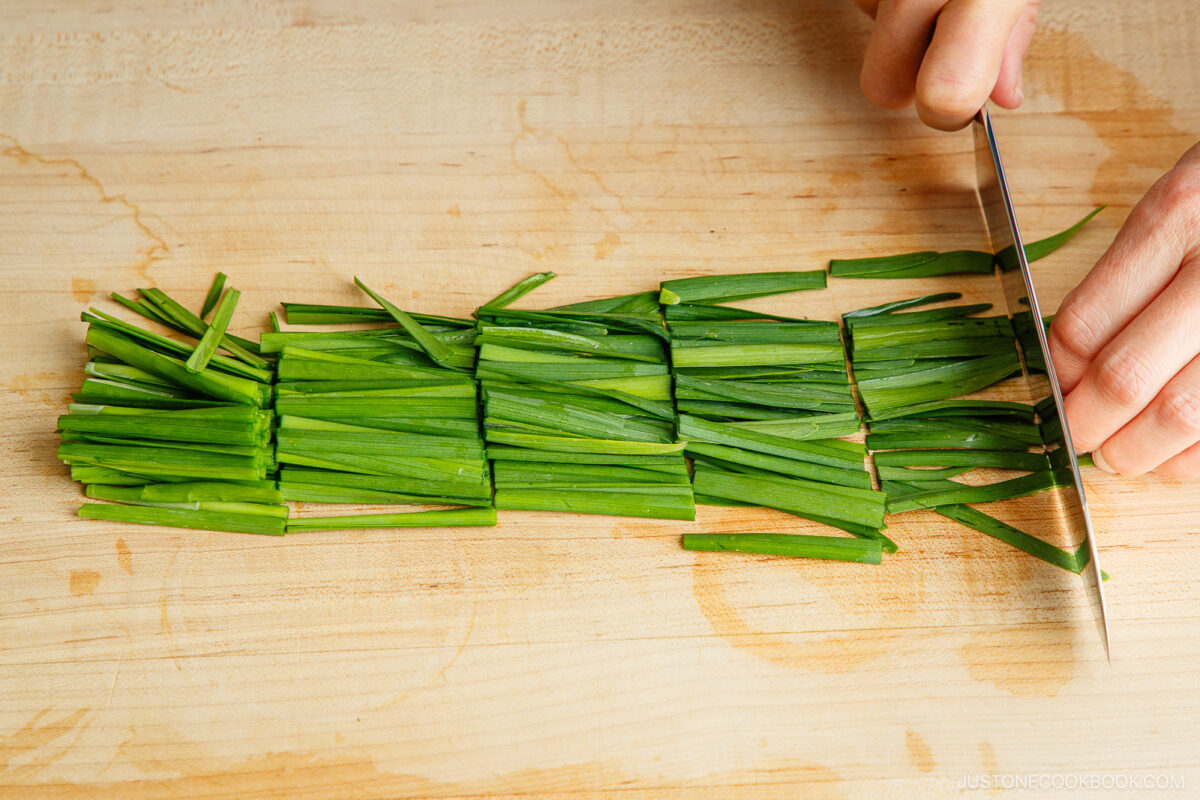 Cutting the garlic chives into 2 inch wide pieces.